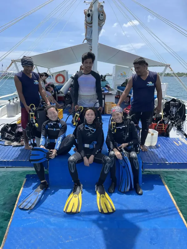 Groupe de plongeurs souriants sur un bateau de plongée en mer