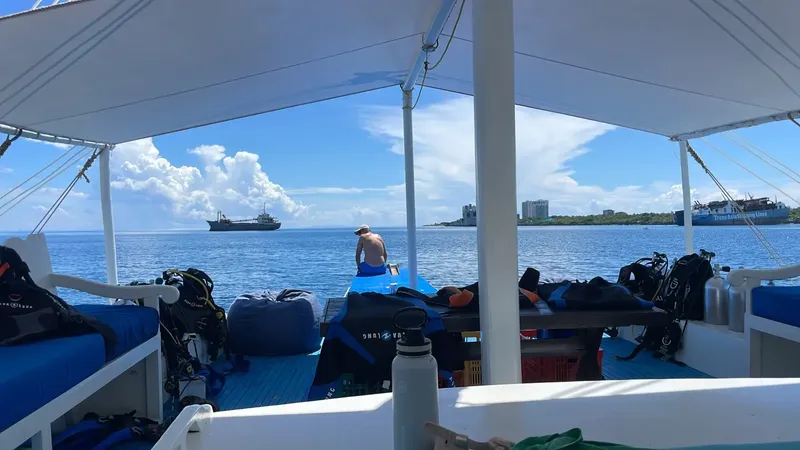 Bateau de plongée avec équipement, une personne assise et mer bleue