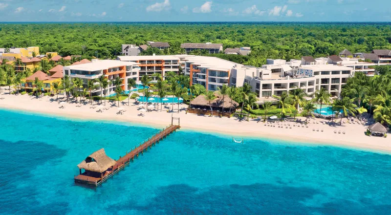 Vue aérienne d'un complexe hôtelier avec ponton sur plage tropicale
