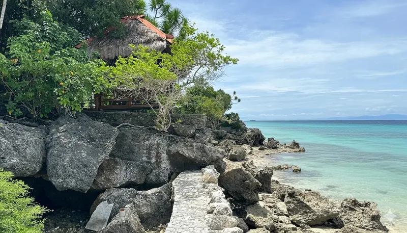 Vue côtière avec une petite structure en bois et la mer turquoise