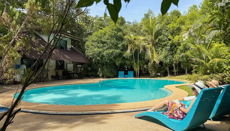 Deux femmes se relaxent au bord d'une piscine dans un cadre tropical
