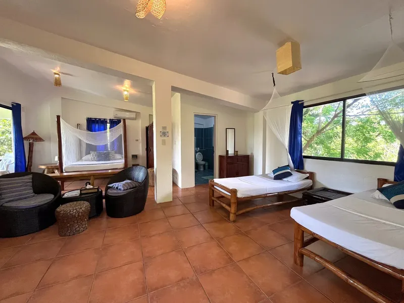 Intérieur d'une chambre spacieuse avec lits, salon et salle de bain