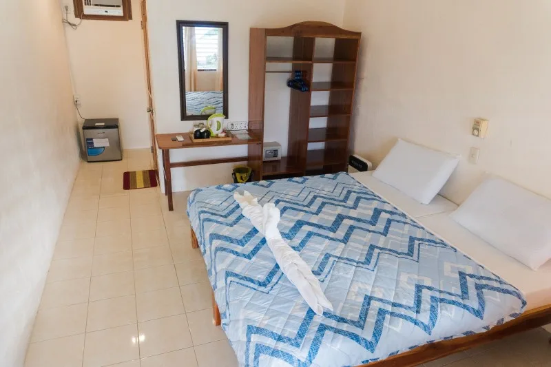 Chambre simple avec un lit, un bureau et un meuble de rangement