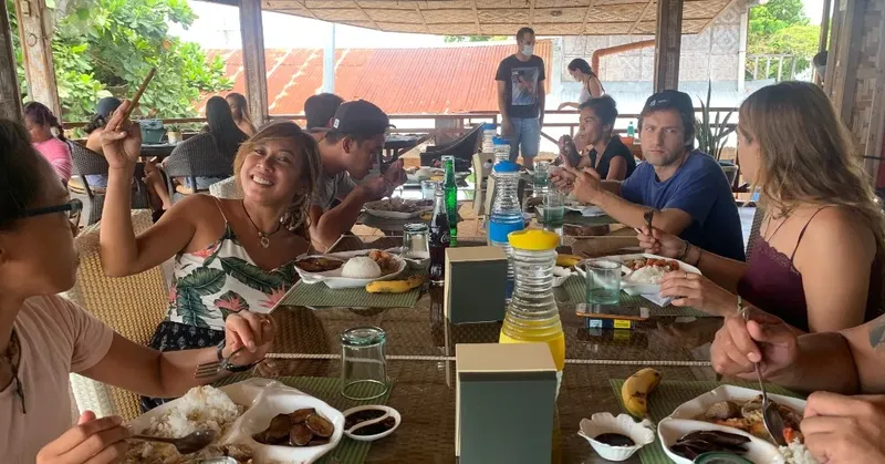 Groupe de personnes souriantes partageant un repas dans un restaurant ouvert