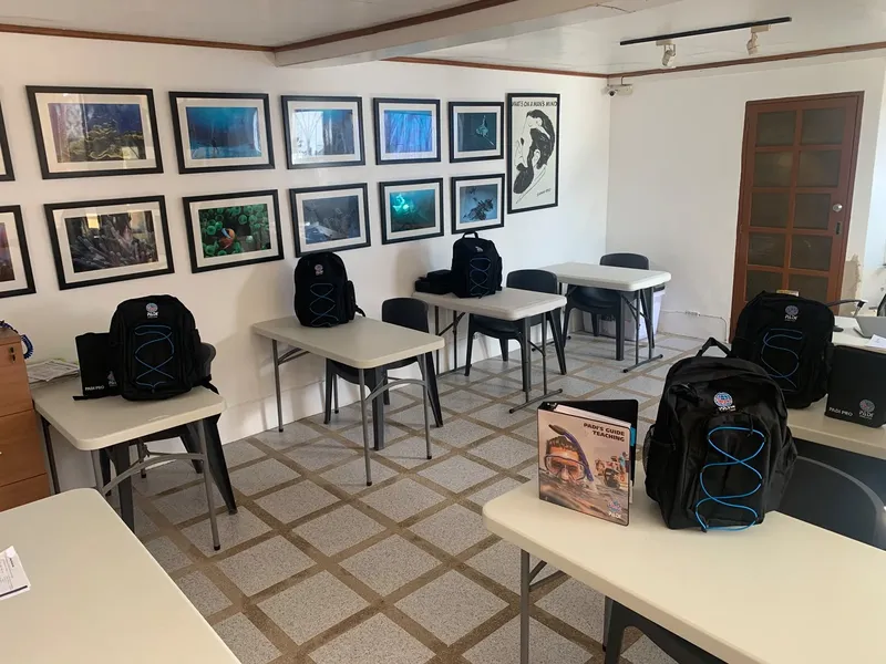 Salle de cours de plongée avec sacs, manuels et photos marines