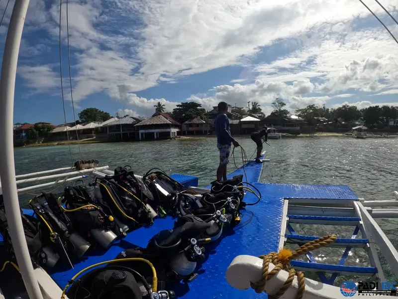 Bateau de plongée avec équipement et plongeur préparant sa descente