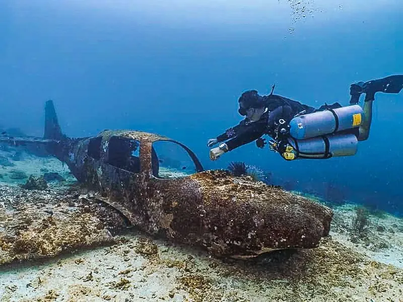 Plongeur explorant l'épave d'un avion au fond de l'océan