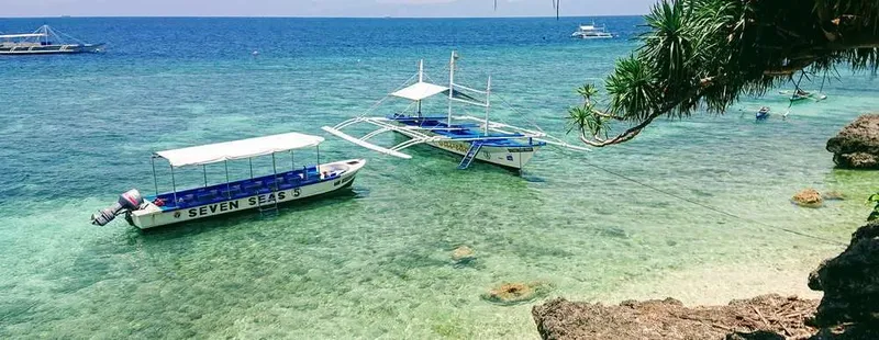 Bateaux de pêche traditionnels ancrés dans une eau turquoise claire