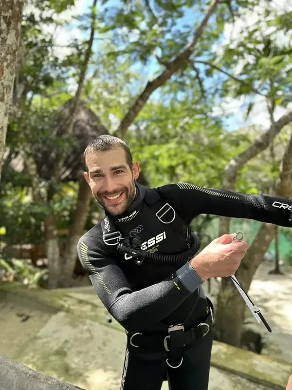 Plongeur souriant en combinaison, équipé, prêt pour une immersion