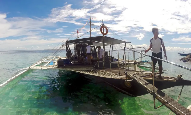 Bateau de transport de plongeurs avec des personnes à bord et un homme debout