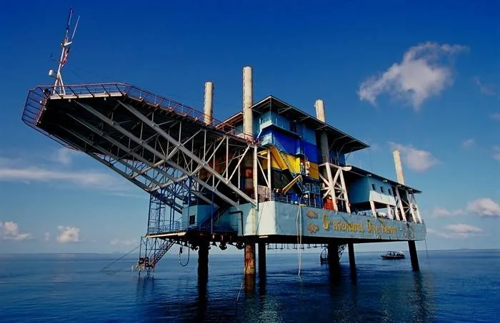 Structure de plongée colorée sur pilotis au-dessus de l'eau turquoise