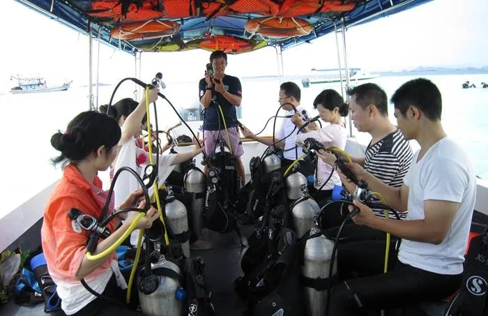 Groupe de plongeurs préparant leur équipement sur un bateau en mer
