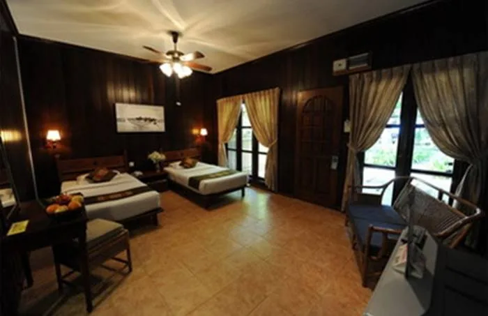 Chambre d'hôtel avec deux lits, décoration boisée et ambiance chaleureuse