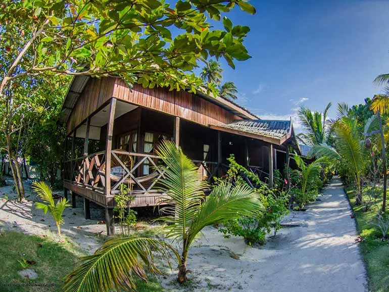 Cabanes en bois sur pilotis au milieu d'une végétation tropicale