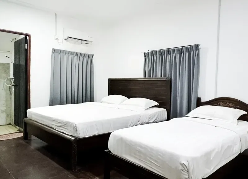 Chambre avec deux lits simples et une salle de bain ouverte