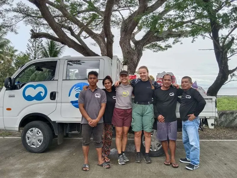 Groupe de personnes souriantes posant devant un pick-up blanc