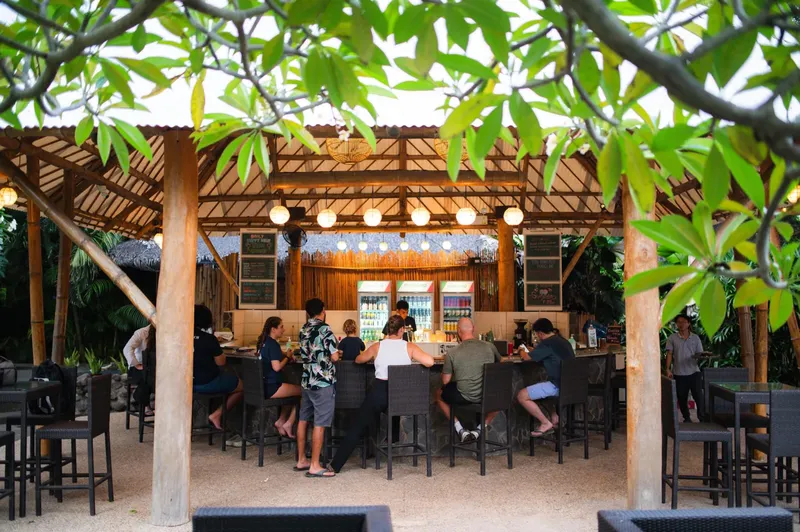 Bar extérieur avec des clients assis sur des tabourets hauts