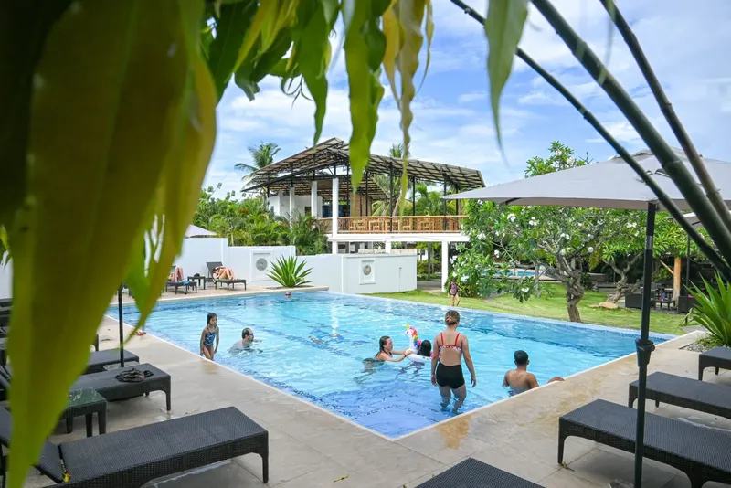 Piscine rectangulaire avec des personnes se baignant et des transats