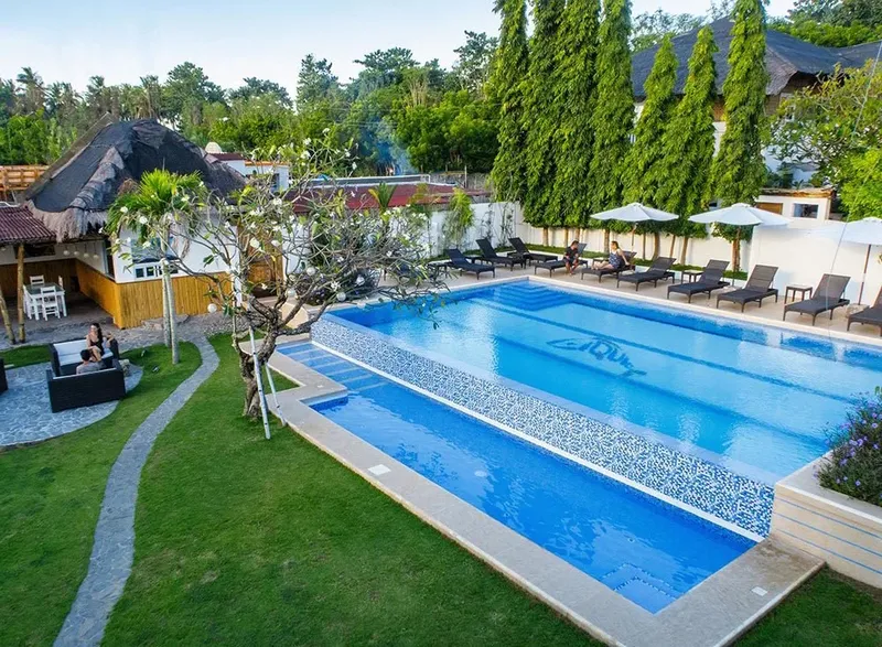 Piscine rectangulaire entourée de transats et d'une végétation luxuriante