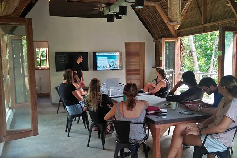 Groupe de personnes en formation dans une salle ouverte sur l'extérieur