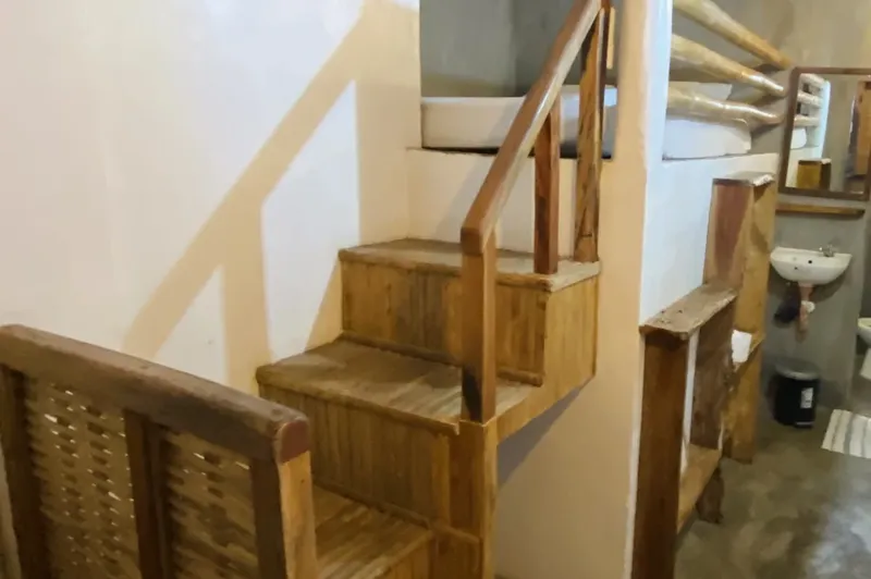 Escalier en bois menant à un lit en hauteur dans une salle
