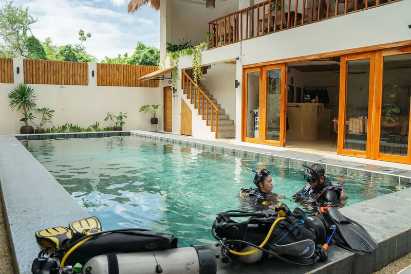 Deux plongeurs en équipement complet dans une piscine au centre