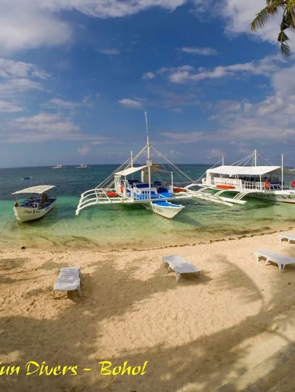 Plage de sable blanc avec bateaux de pêche traditionnels ancrés au large