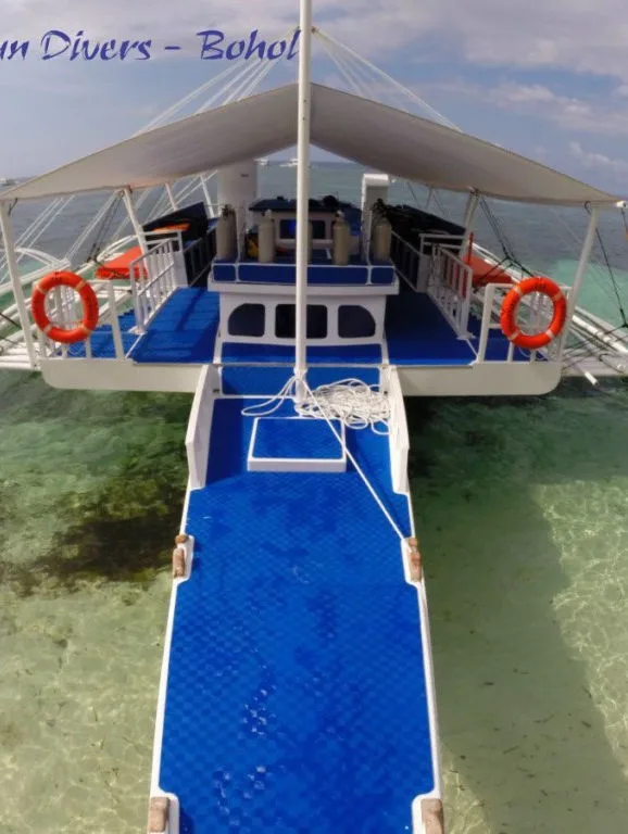 Vue aérienne d'un bateau de plongée bleu et blanc au-dessus d'un récifal