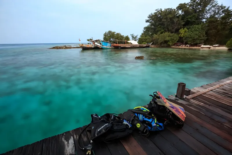 Equipement de plongée sur un ponton en bois face à la mer