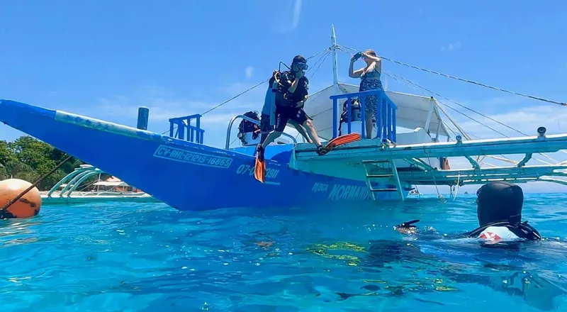 Plongeurs sur un bateau bleu, préparation pour une immersion en mer