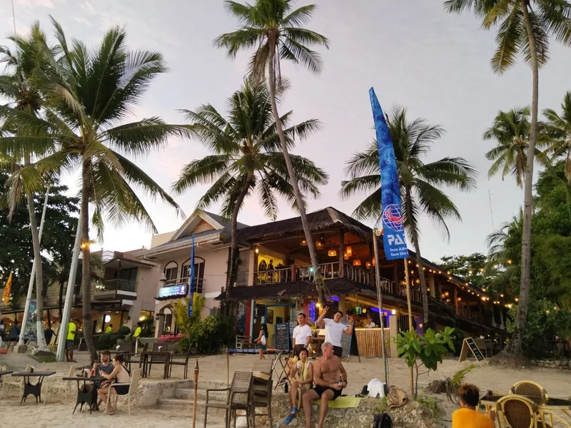 Vue d'un centre de plongée avec des personnes sur une plage tropicale