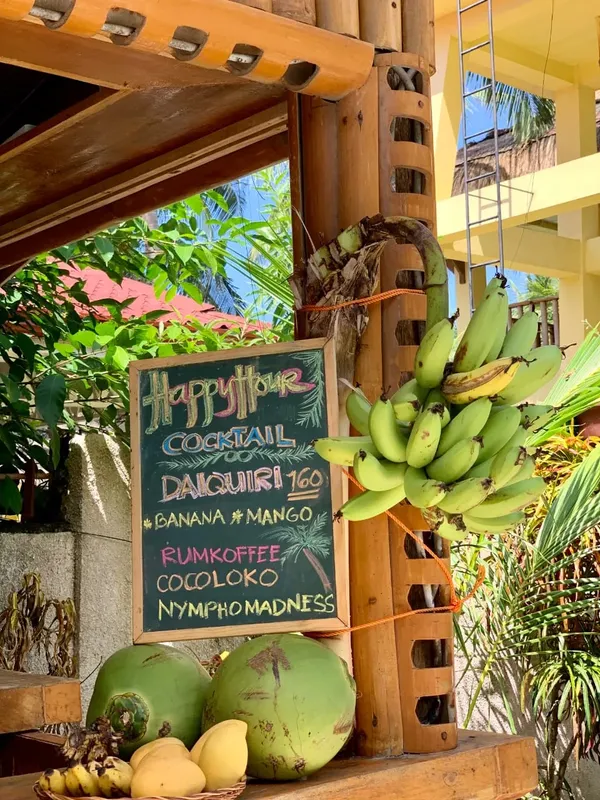 Panneau Happy Hour avec liste de cocktails et fruits tropicaux frais