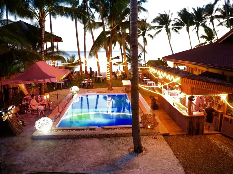 Vue d'un centre de plongée avec piscine, tables et végétation tropicale