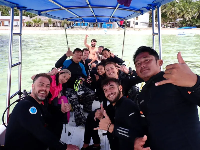 Groupe de plongeurs souriants à bord d'un bateau en mer
