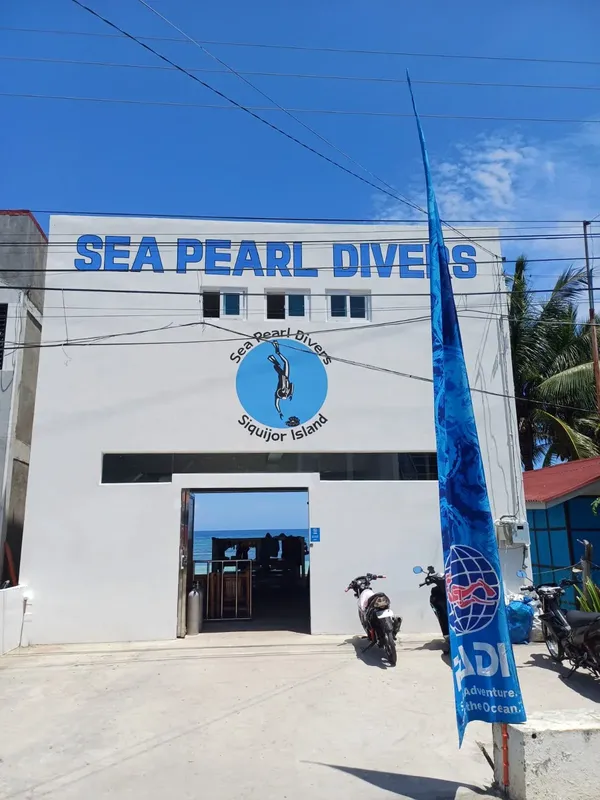 Façade d'un centre de plongée avec des personnes et un drapeau bleu
