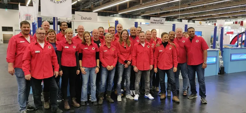 Groupe de personnes souriantes portant des chemises rouges dans un hall