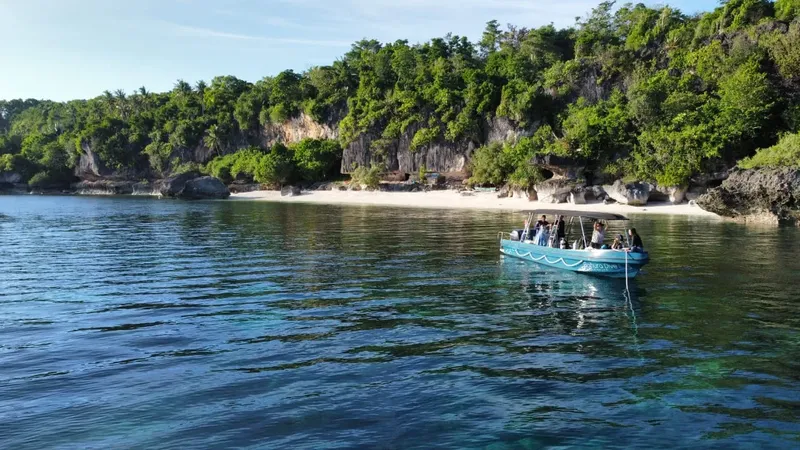 Bateau de plongée avec passagers naviguant vers une plage tropicale