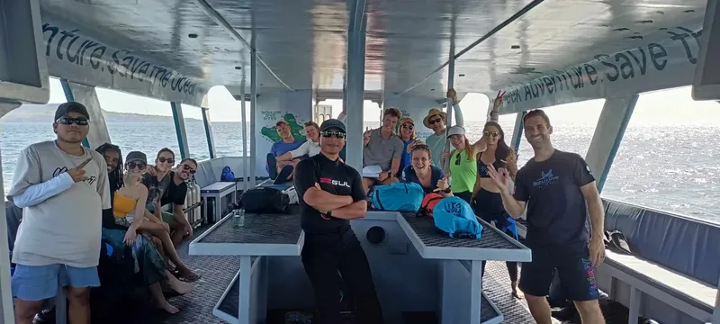 Groupe de plongeurs souriants à bord d'un bateau de plongée en mer