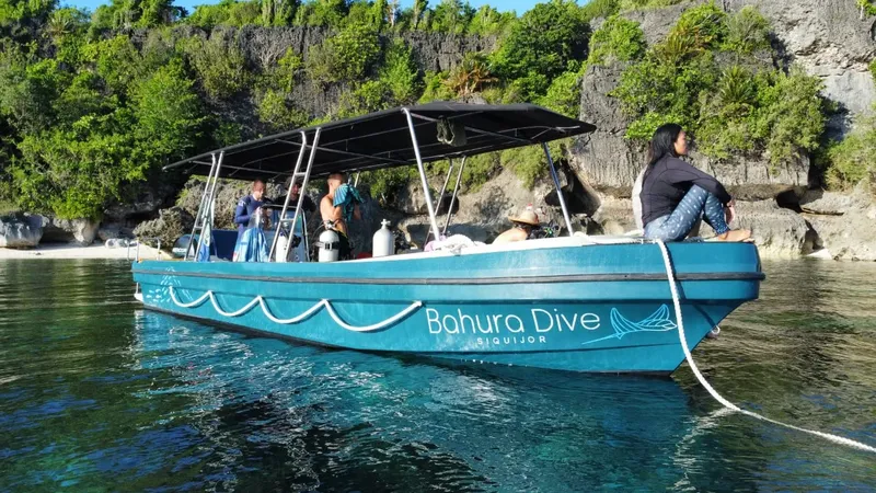 Bateau de plongée bleu avec des passagers et des équipements à bord