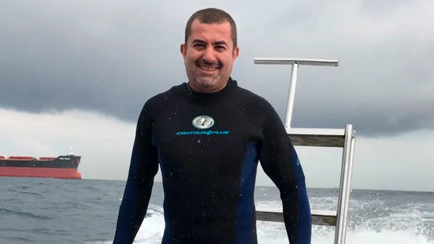 Homme souriant en combinaison de plongée sur un bateau en mer