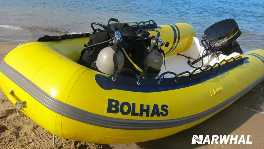 Bateau de plongée jaune échoué sur une plage de sable clair