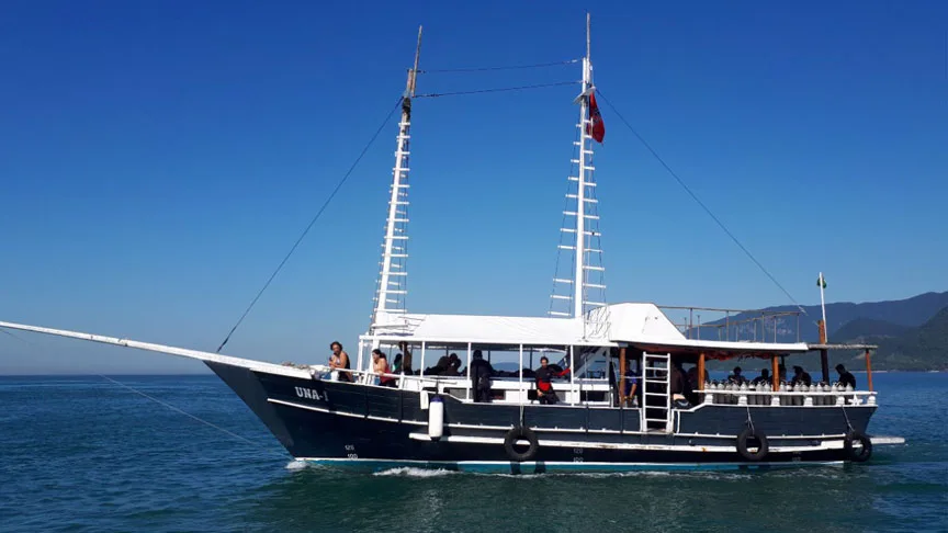Bateau de plongée avec des passagers, mer bleue, ciel clair, journée ensoleillée