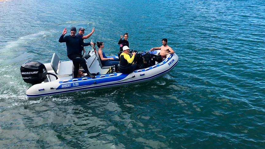 Groupe de plongeurs sur un bateau semi-rigide en pleine mer
