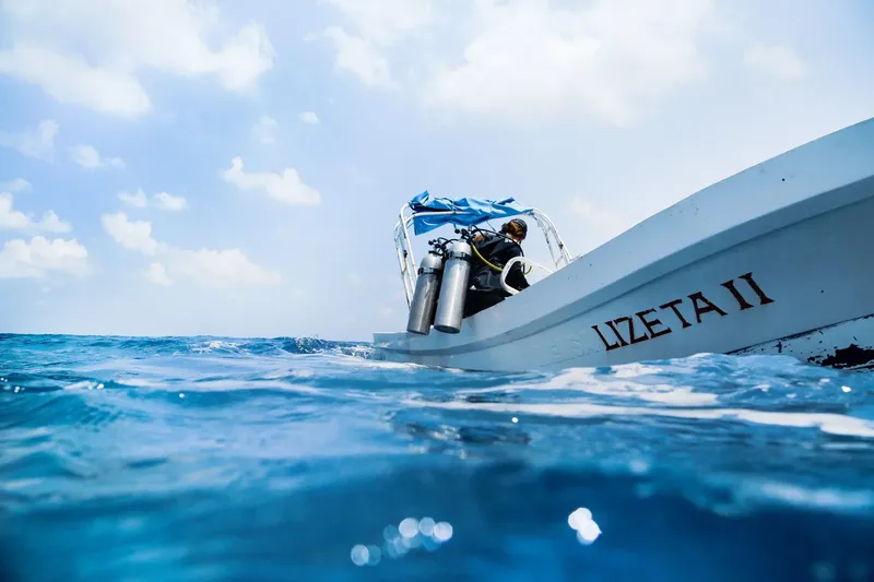 Plongeur équipé s'apprête à plonger depuis un bateau en mer