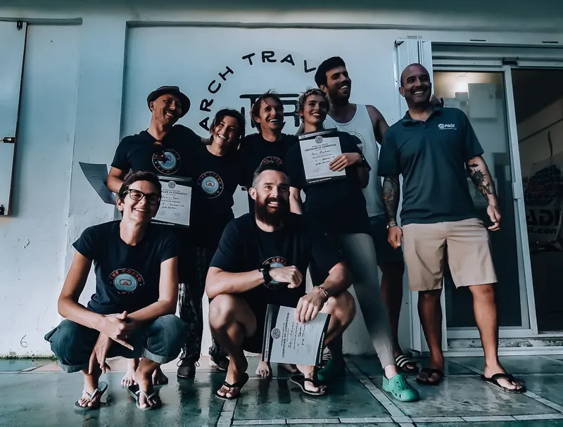 Groupe de personnes souriantes posant avec des certificats de plongée
