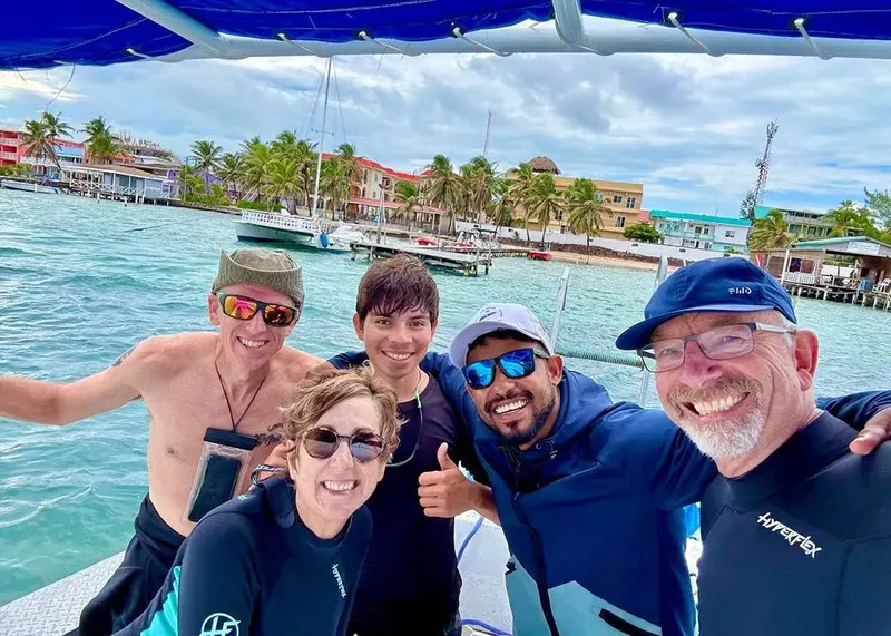 Groupe de personnes souriantes sur un bateau en mer, ambiance joyeuse