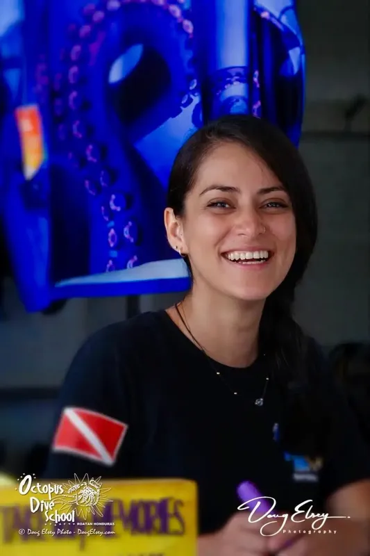 Portrait souriant d'une femme plongeuse devant un décor bleu abstrait