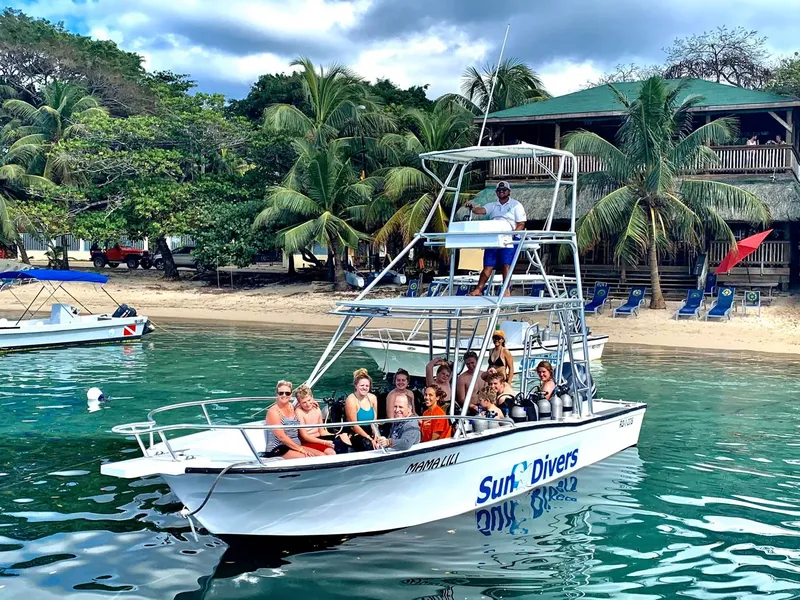 Groupe de plongeurs sur un bateau avec le logo Sun Divers
