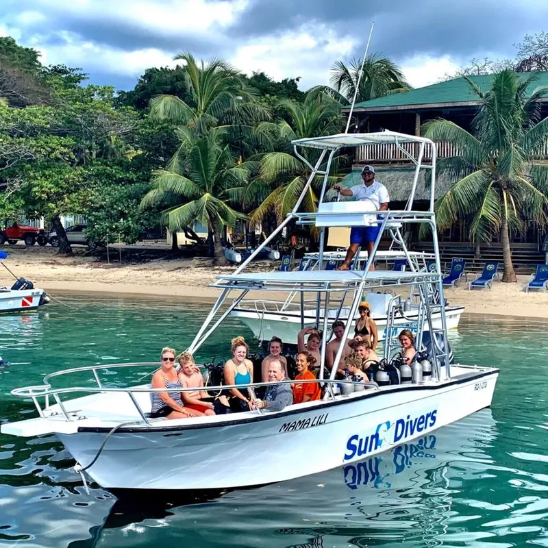 Groupe de plongeurs sur un bateau blanc avec le nom du centre