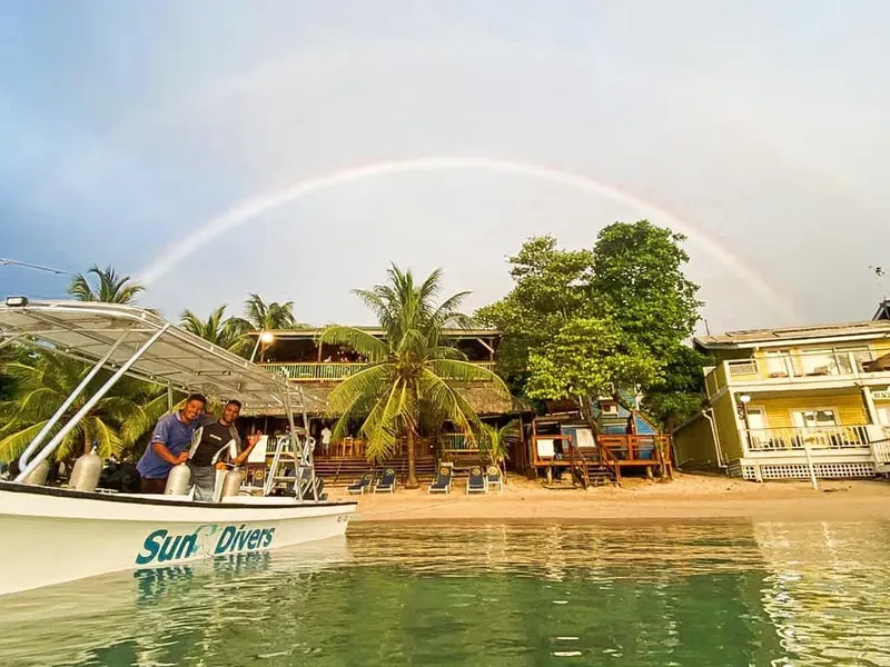 Bateau de plongée devant un centre avec un arc-en-ciel tropical